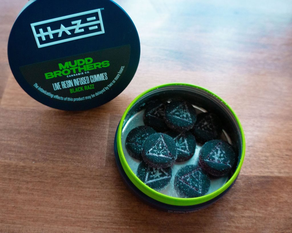 Shore House Canna dispensary product shot at our West Cape May dispensary: an open tin of Mudd Brothers Live Resin Infused Gummies Black Razz beside its HAZE‑branded lid.